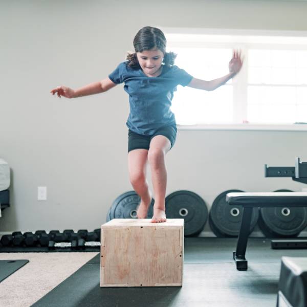 Kid jumping over obstacles on a training
